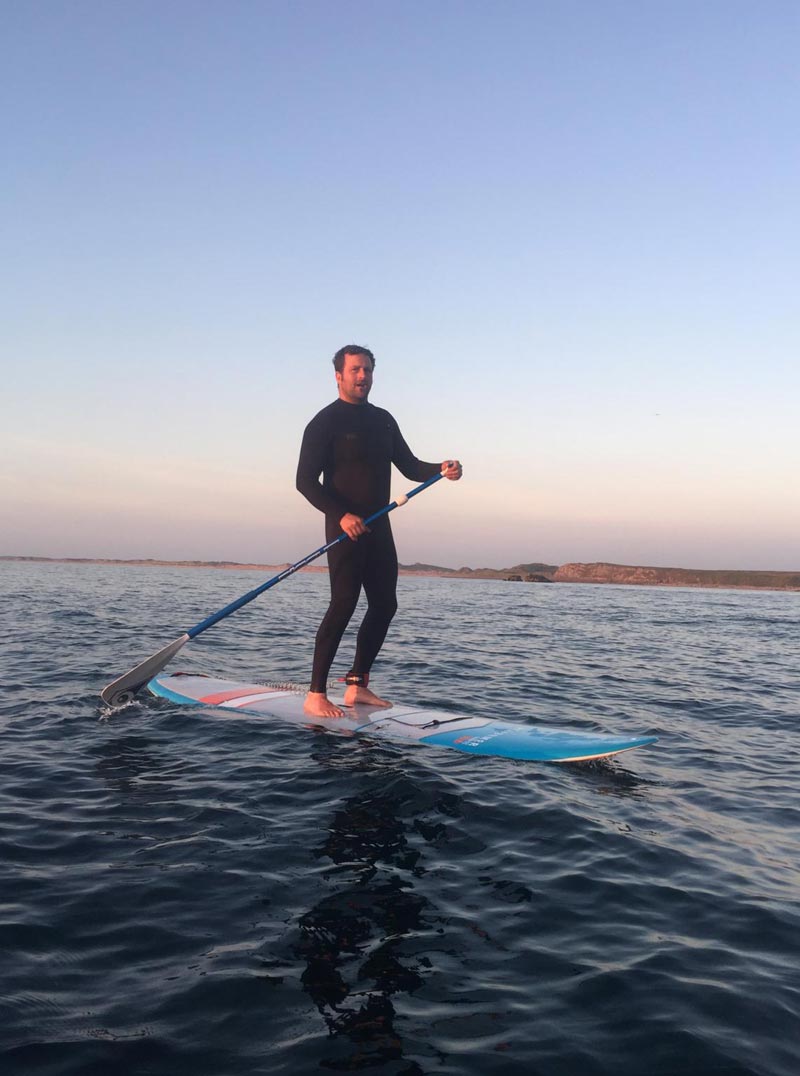 A man doing stand up paddle boarding